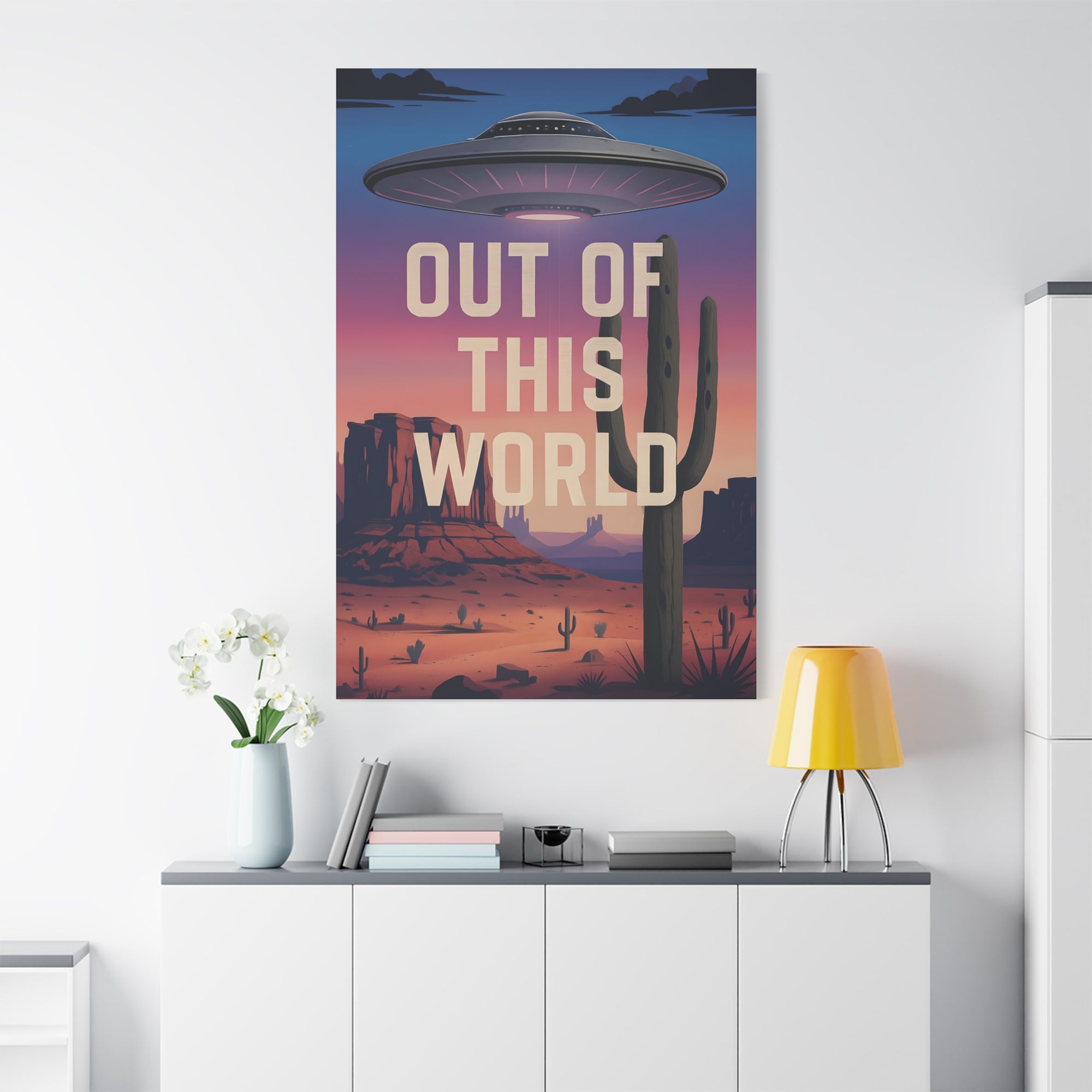 Poster with UFO and cactus design on a wall above a white cabinet.