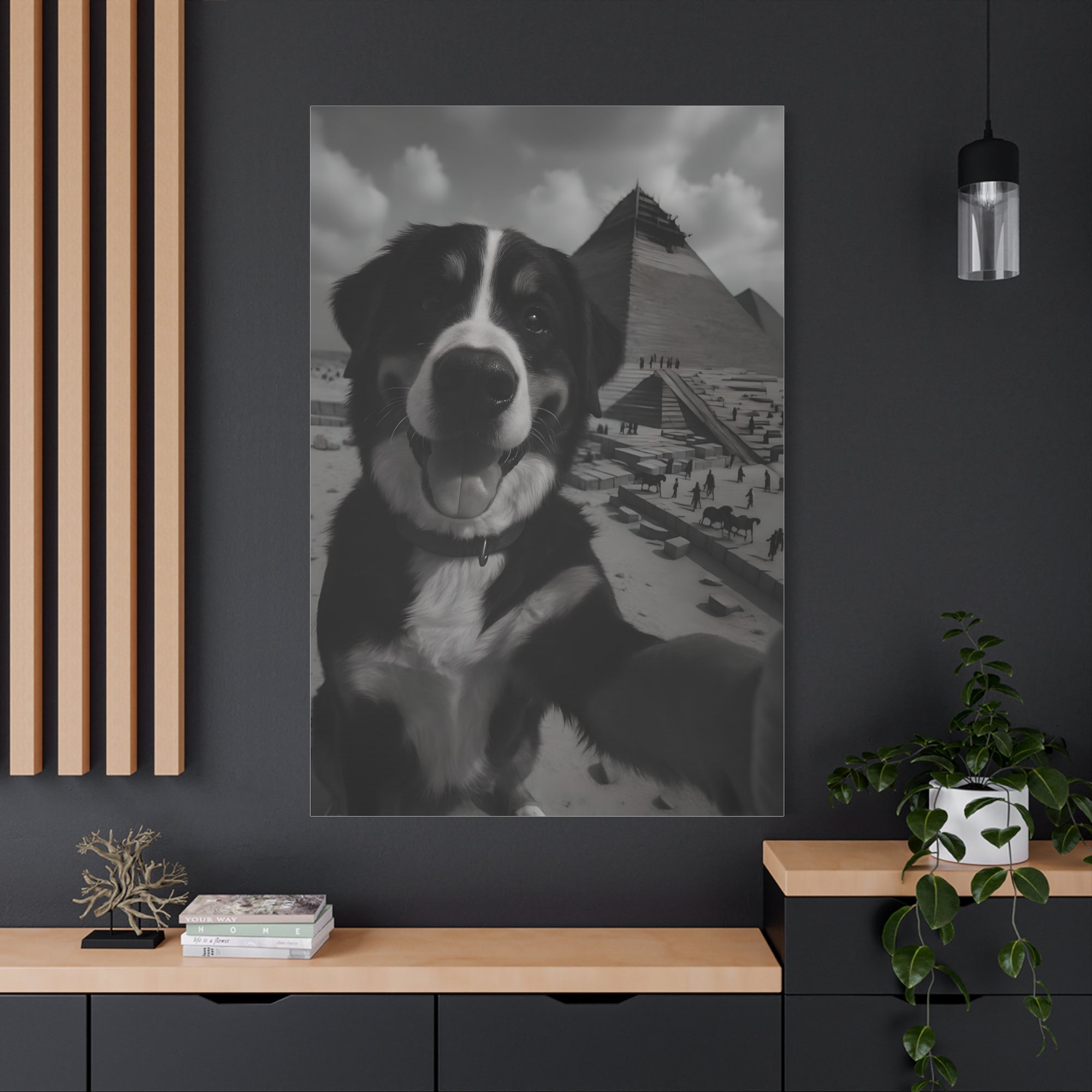 Framed black and white photo of a dog on a beach with mountains in the background, hanging on a dark wall.